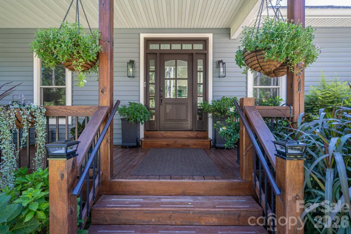 Inviting covered porch with warm wood accents and welcoming entry. Welcome Home