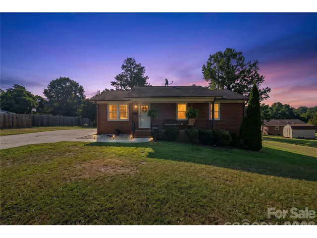 AI-Twilight view of the front of home fully fenced in yard
