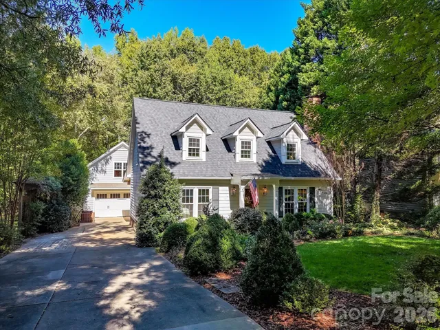 This charming home offers timeless curb appeal with classic architecture, welcoming covered front porch, beautiful landscaping, and a lush, tree-lined setting.