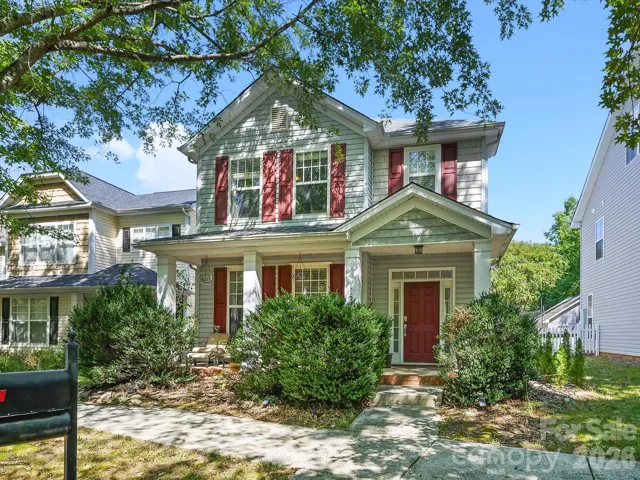 A charming two-story home with a welcoming covered front porch, mature landscaping, and classic architectural details creates inviting curb appeal.