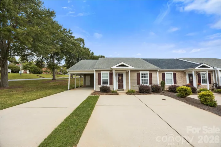 Front of home with driveway and carport and 2 parking spaces directly in front of unit.