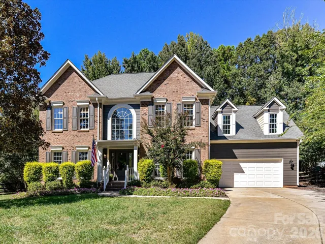 This beautiful two-story brick home offers timeless curb appeal with elegant architectural details, a grand arched window, manicured landscaping, a welcoming covered front entry, and an attached two-car garage.