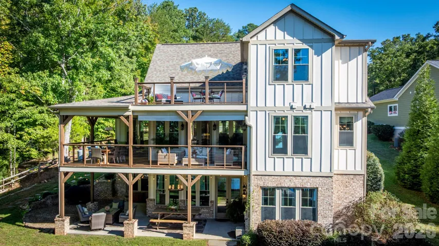 Designed to embrace the waterfront setting, the expansive L-shaped covered porch offers an exceptional outdoor living experience, with desirable southern exposure and sweeping views of Lake Norman.