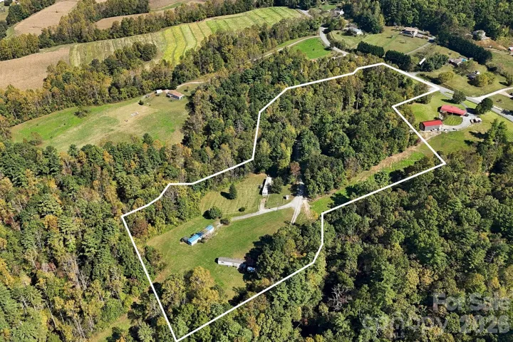Elevated perspective highlights the extensive wooded acreage, open clearings, and established access throughout this versatile property.