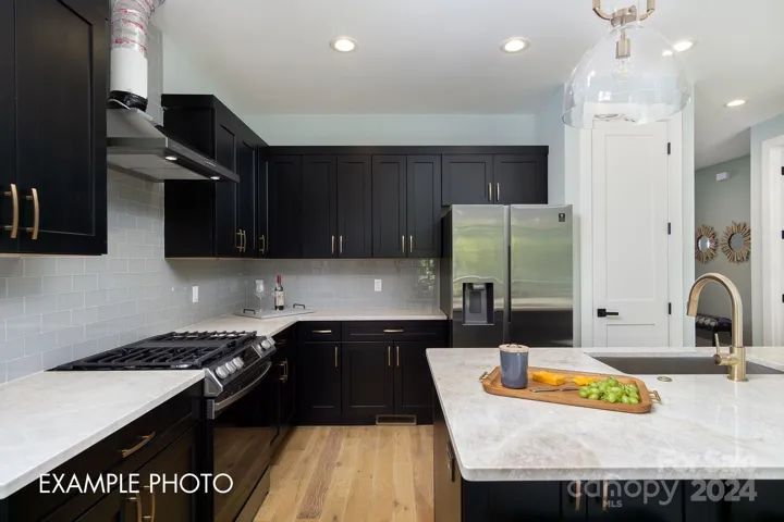 Example photo of spacious kitchen with granite countertops and custom cabinets.