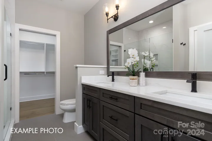 Example photo. Double vanity in en-suite primary bathroom, which connects to the spacious to walk-in closet.