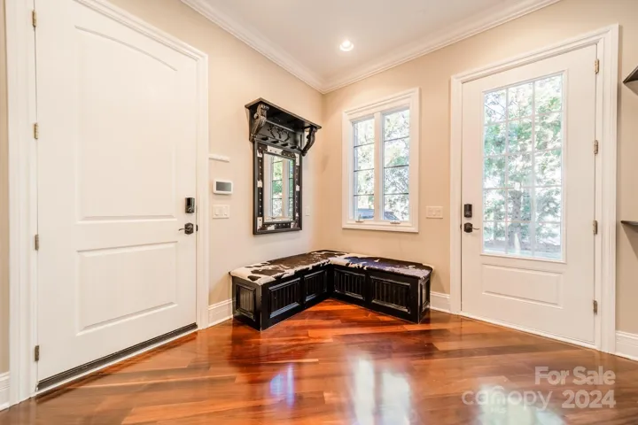 Large mudroom off the 3-car garage and the kitchen with coat closet and built-ins.