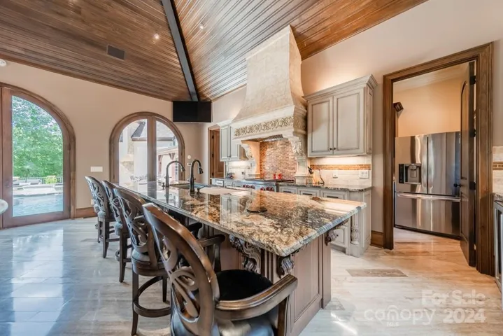 Cabana: full bathroom, laundry room, refrigerator, beverage refrigerator, huge island, travertine tile floors, ice machine, oversized kitchen sink, ...