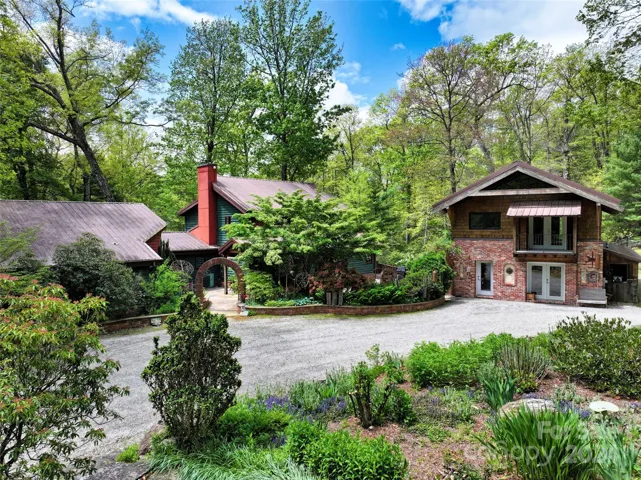 Welcome home to the lovely main house (left) and unfinished custom timber frame building (right). Beautiful gardens and mature trees surround this peaceful home.