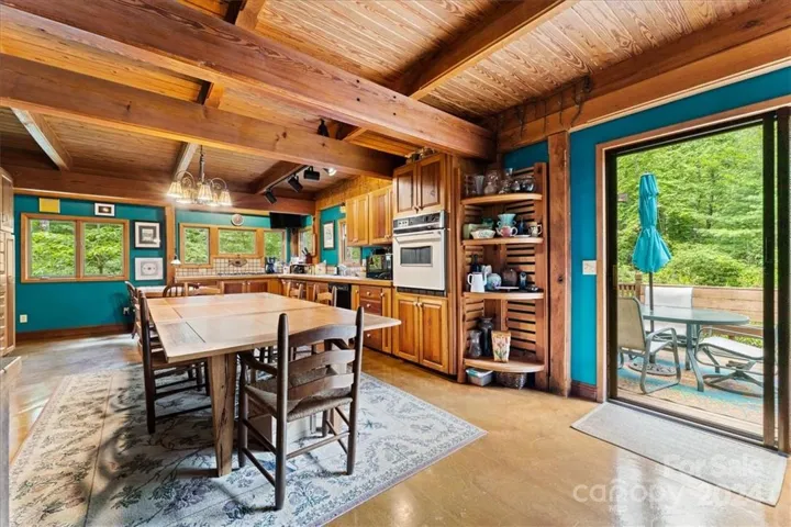Kitchen (1) in main house with custom woodwork, cabinetry, and sliding glass door that leads to private deck.