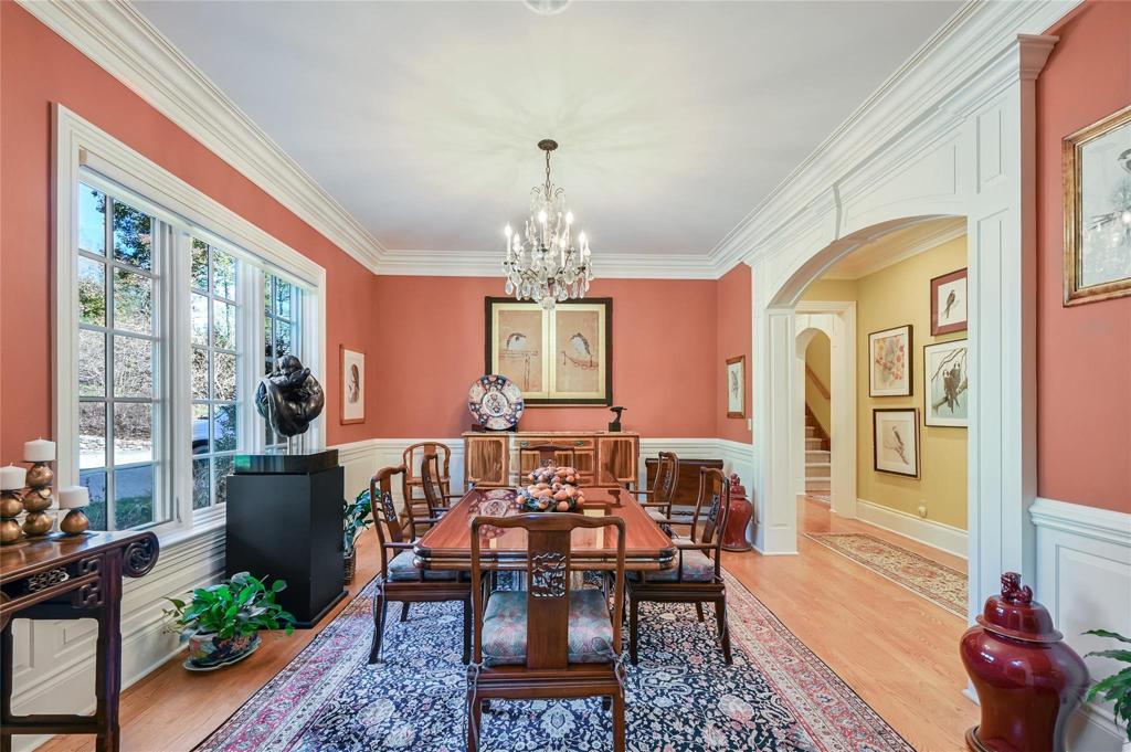 Large dining room with custom woodwork, open to foyer and hallway to kitchen