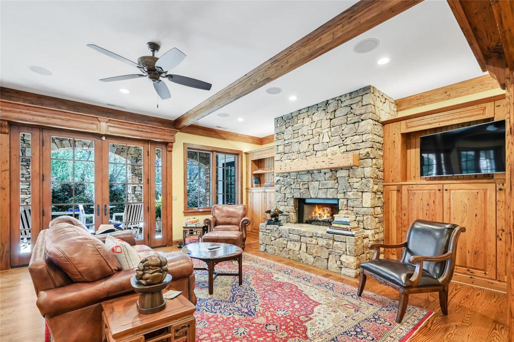 Lower level family room with stone fireplace and cabinets made with wormy chestnut wood.