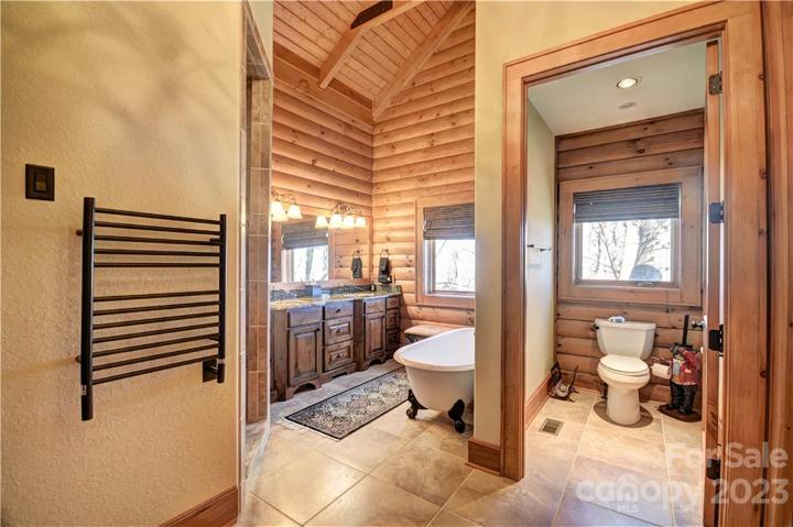 Primary Bath with dual vanity sinks and clawfoot tub, note the towel warming rack on the left