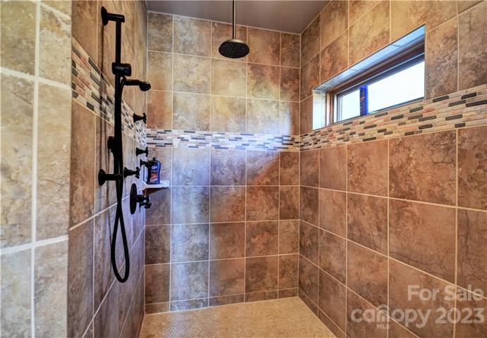 Open and tiled shower in the primary bathroom