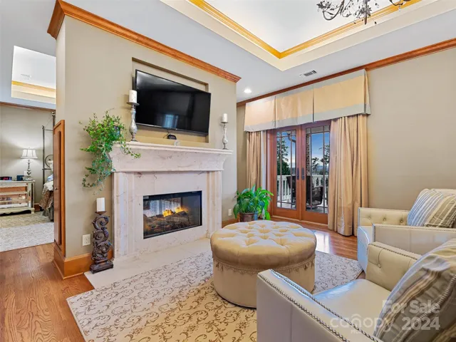 This Sitting Area in the Primary Suite offers private access to both a covered deck as well as an open deck through those glass French doors