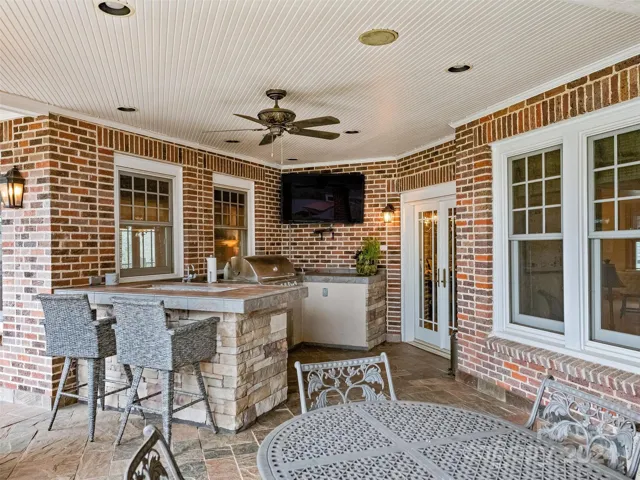 The outdoor entertaining continues while grilling at the outdoor kitchen (with a sink and a refrigerator) while viewing games on the big screen!