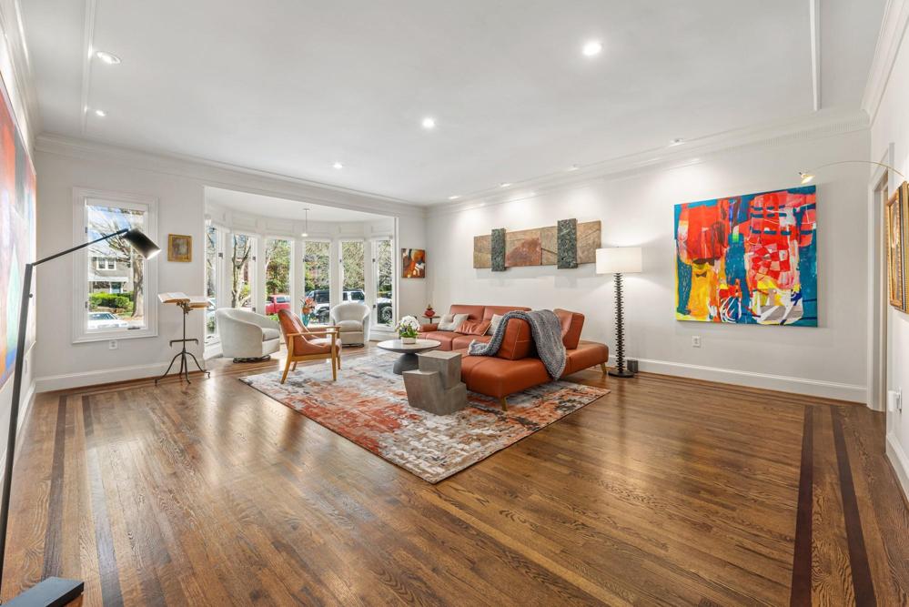 Light filled living room with inlaid wood floors and gallery lighting.