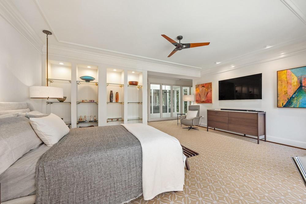 Primary bedroom with bedside lighting and display shelving.