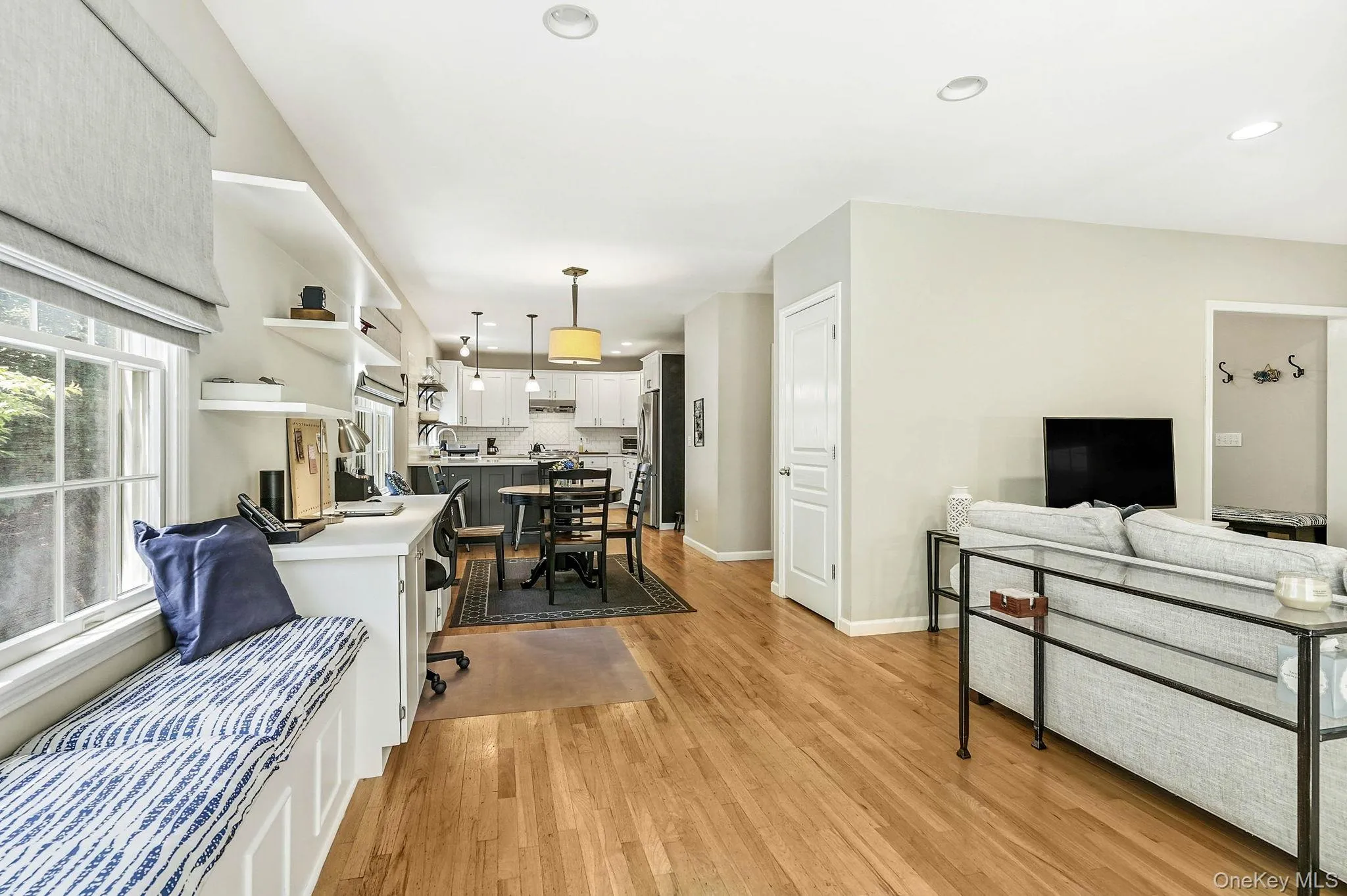 Open-concept living area featuring wood-finish flooring, recessed lighting, and a neutral color palette Open-concept living area featuring wood-finish flooring, recessed lighting, and a neutral color palette