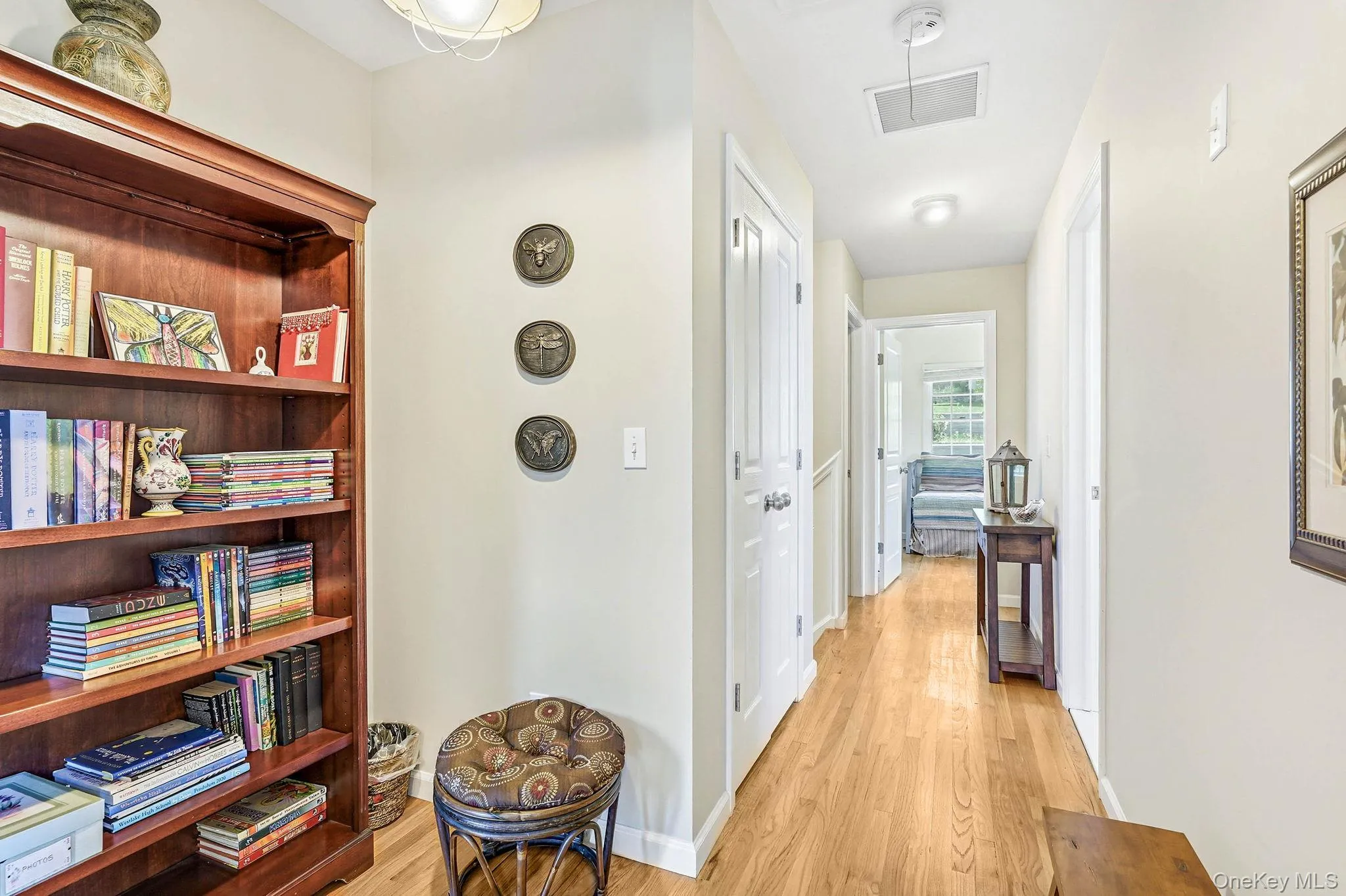 Hallway with wood-finish flooring, white doors, and light-colored walls Hallway with wood-finish flooring, white doors, and light-colored walls