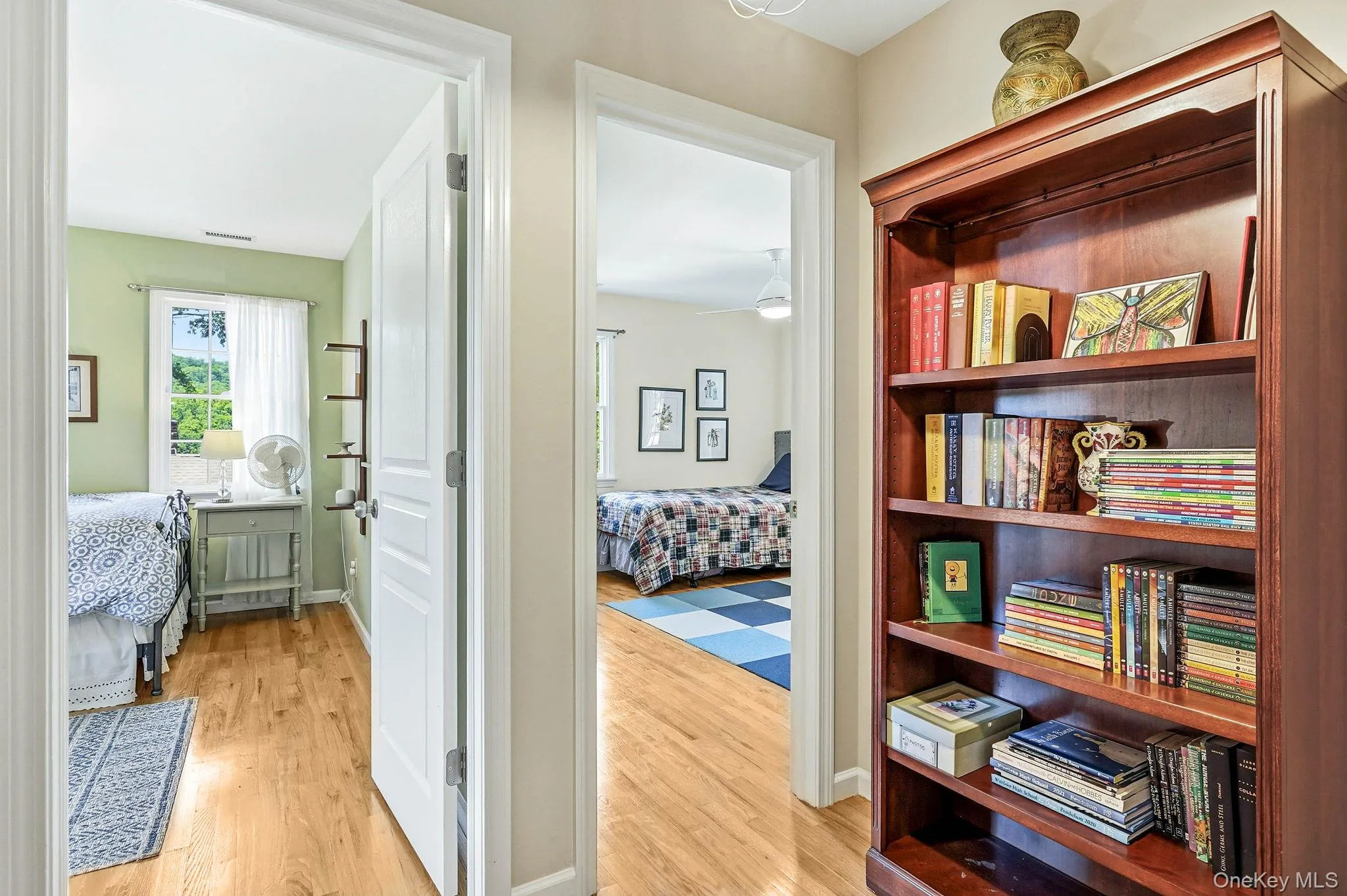 Hallway featuring a built-in wood bookcase with adjustable shelving Hallway featuring a built-in wood bookcase with adjustable shelving