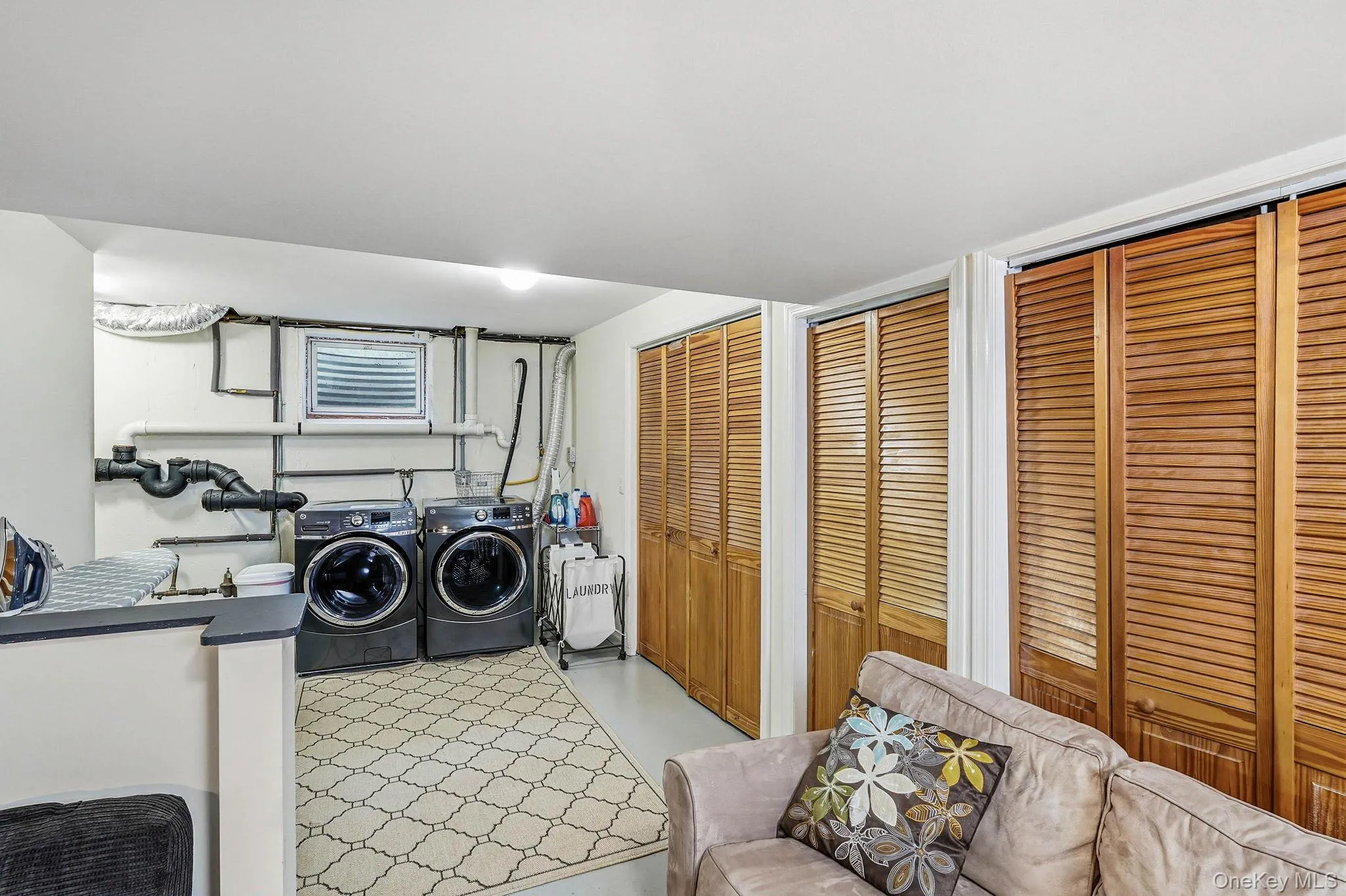 Dedicated laundry area featuring modern appliances and a small window Dedicated laundry area featuring modern appliances and a small window