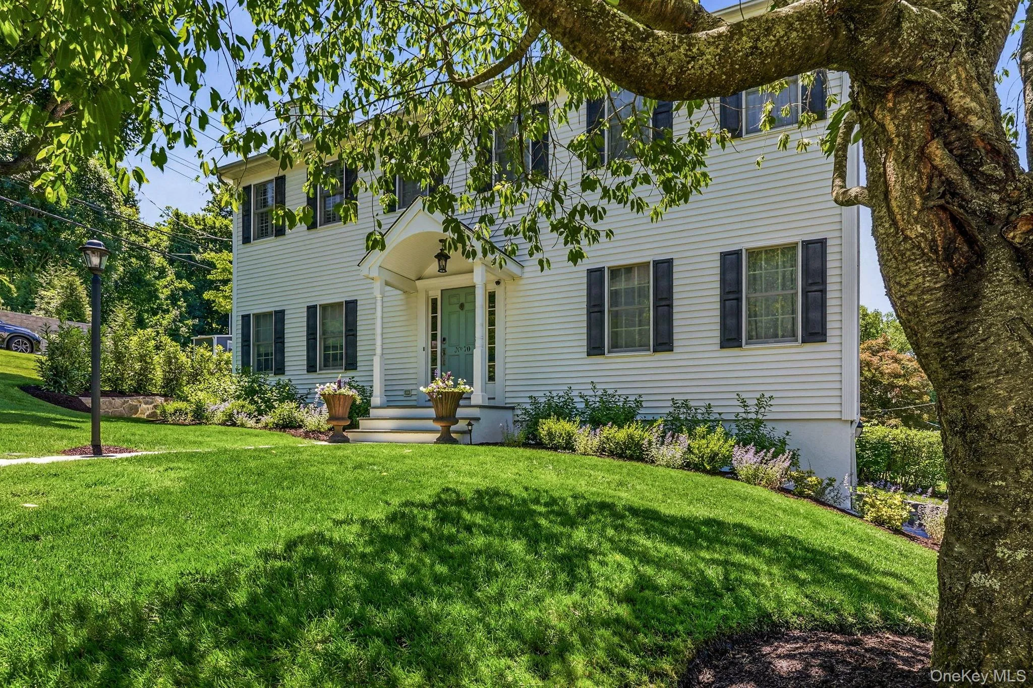 Two-story residence featuring white siding and dark shutters Two-story residence featuring white siding and dark shutters