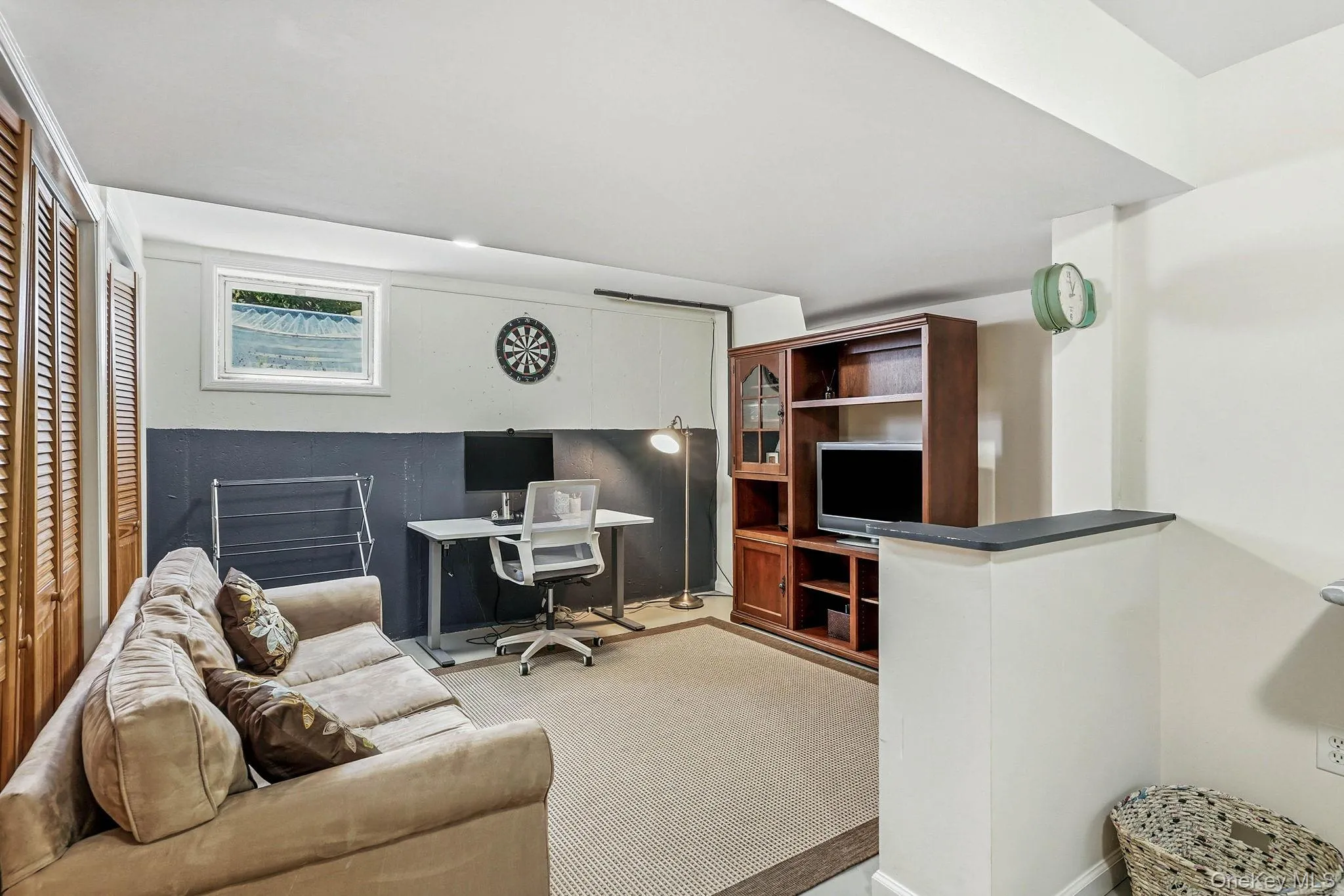 Finished lower level offering wood-finish louvered doors, painted walls, overhead lighting, and a built-in media cabinet Finished lower level offering wood-finish louvered doors, painted walls, overhead lighting, and a built-in media cabinet