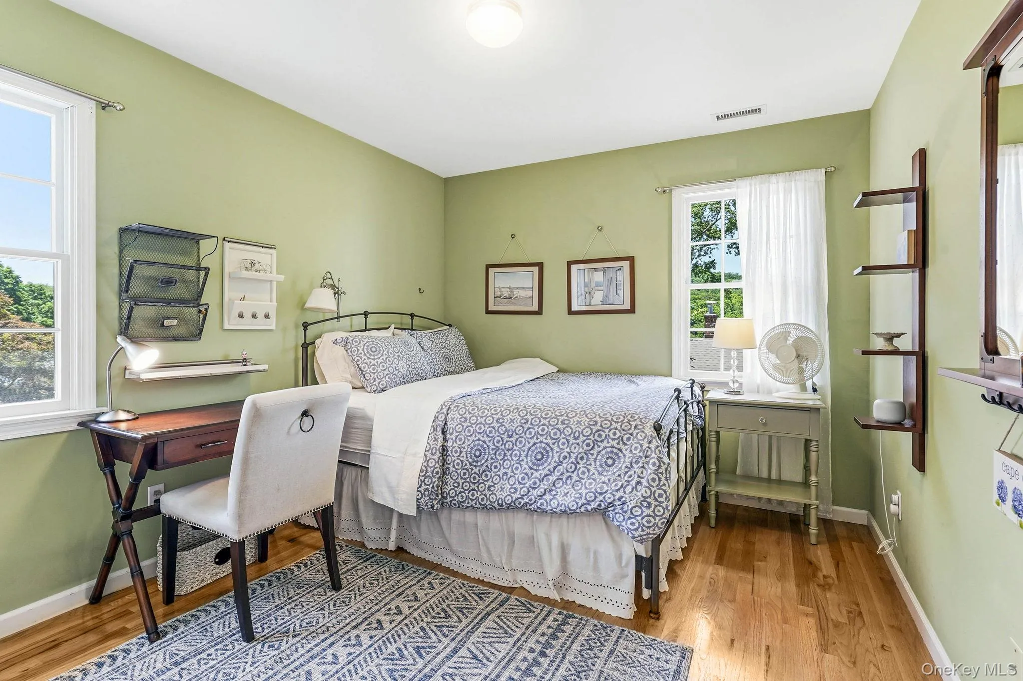 Spacious room featuring two windows, hard surface flooring, and a ceiling-mounted light fixture Spacious room featuring two windows, hard surface flooring, and a ceiling-mounted light fixture