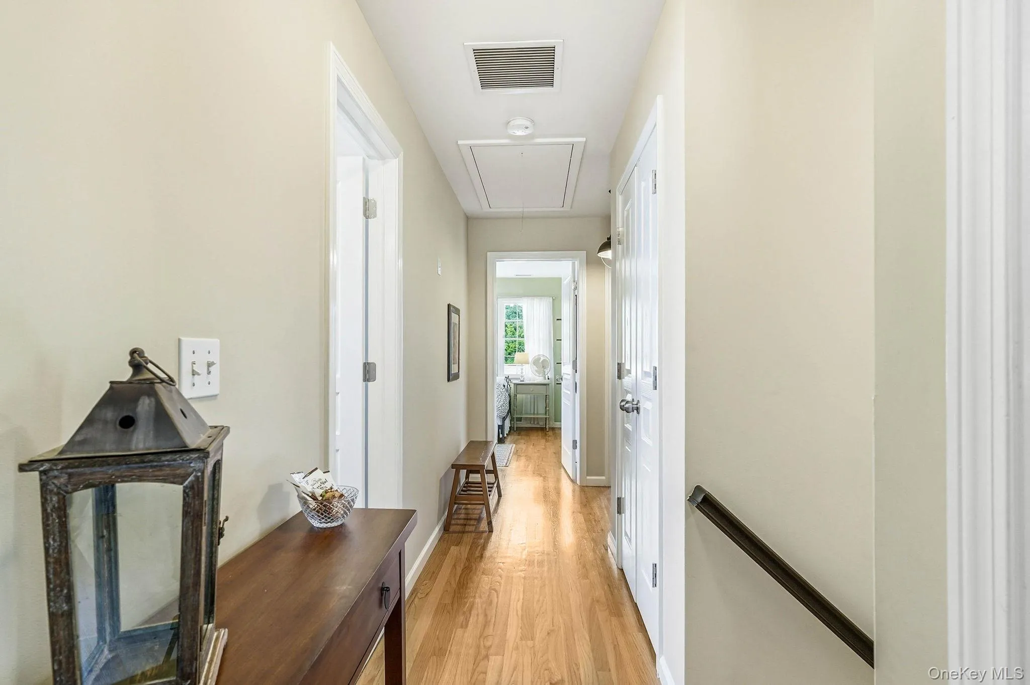Hardwood flooring extends throughout this hallway with painted walls and white trim Hardwood flooring extends throughout this hallway with painted walls and white trim