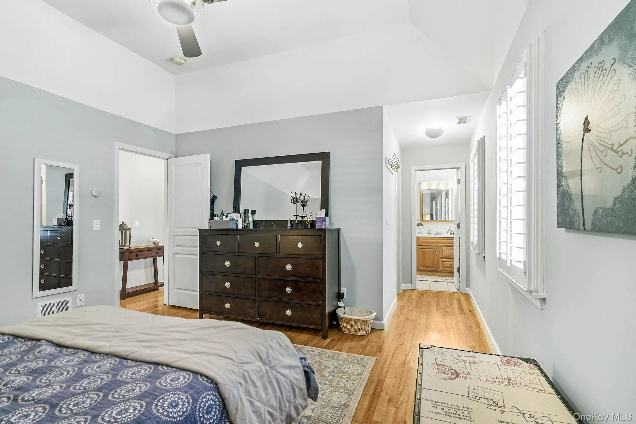 Vaulted ceilings with a ceiling fan, hardwood flooring, and bright white window shutters Vaulted ceilings with a ceiling fan, hardwood flooring, and bright white window shutters