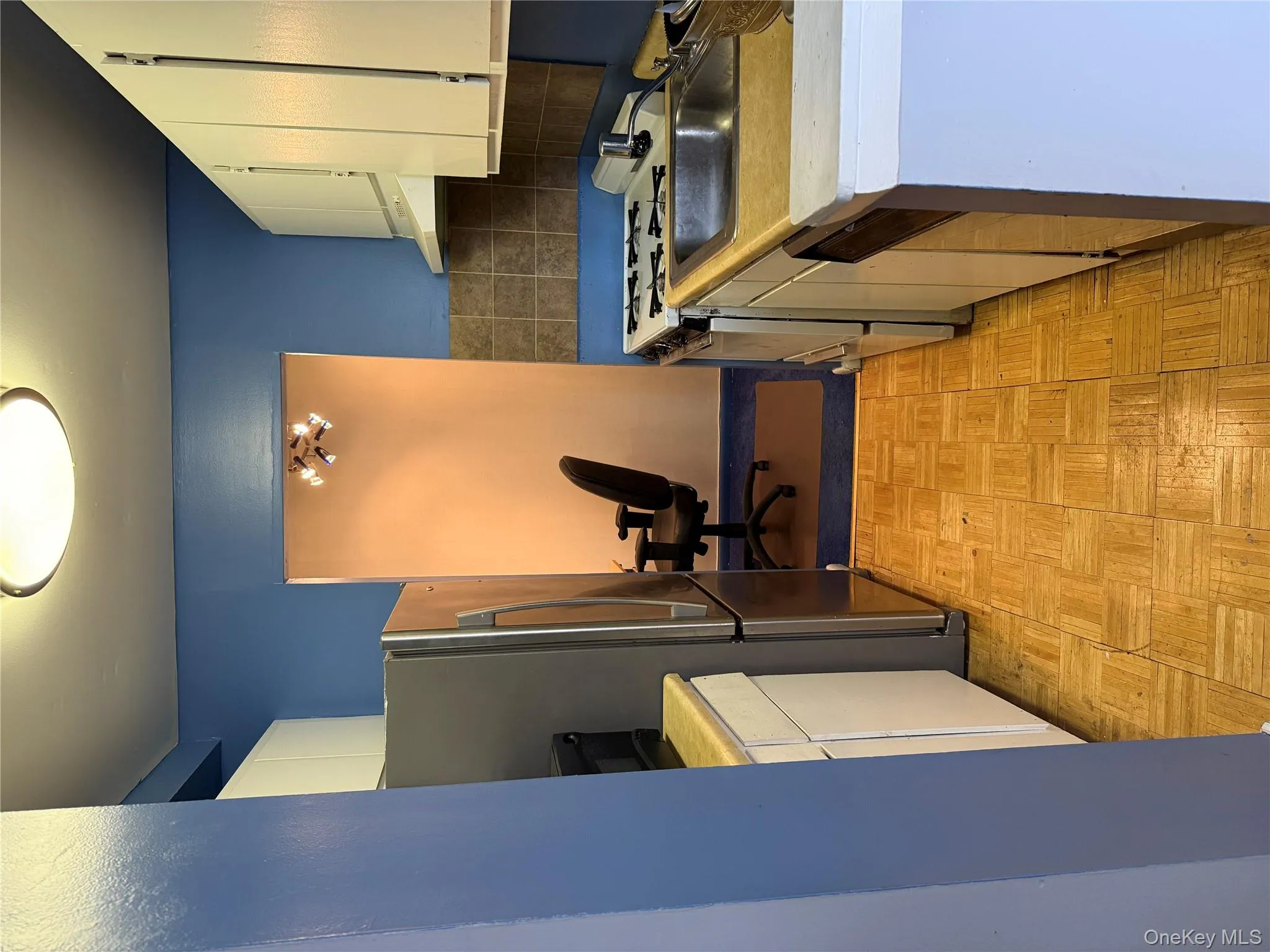 Kitchen featuring white cabinets, appliances with stainless steel finishes, light countertops, range hood, and decorative backsplash Kitchen featuring white cabinets, appliances with stainless steel finishes, light countertops, range hood, and decorative backsplash