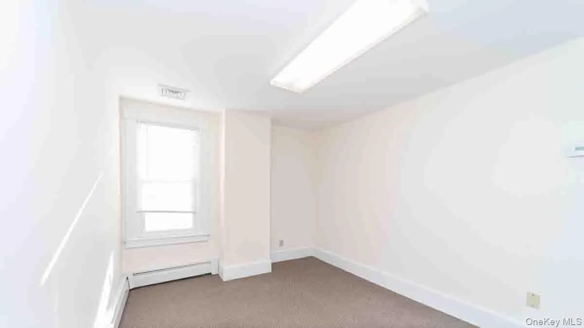 Unfurnished room with visible vents, baseboards, and baseboard heating Unfurnished room with visible vents, baseboards, and baseboard heating