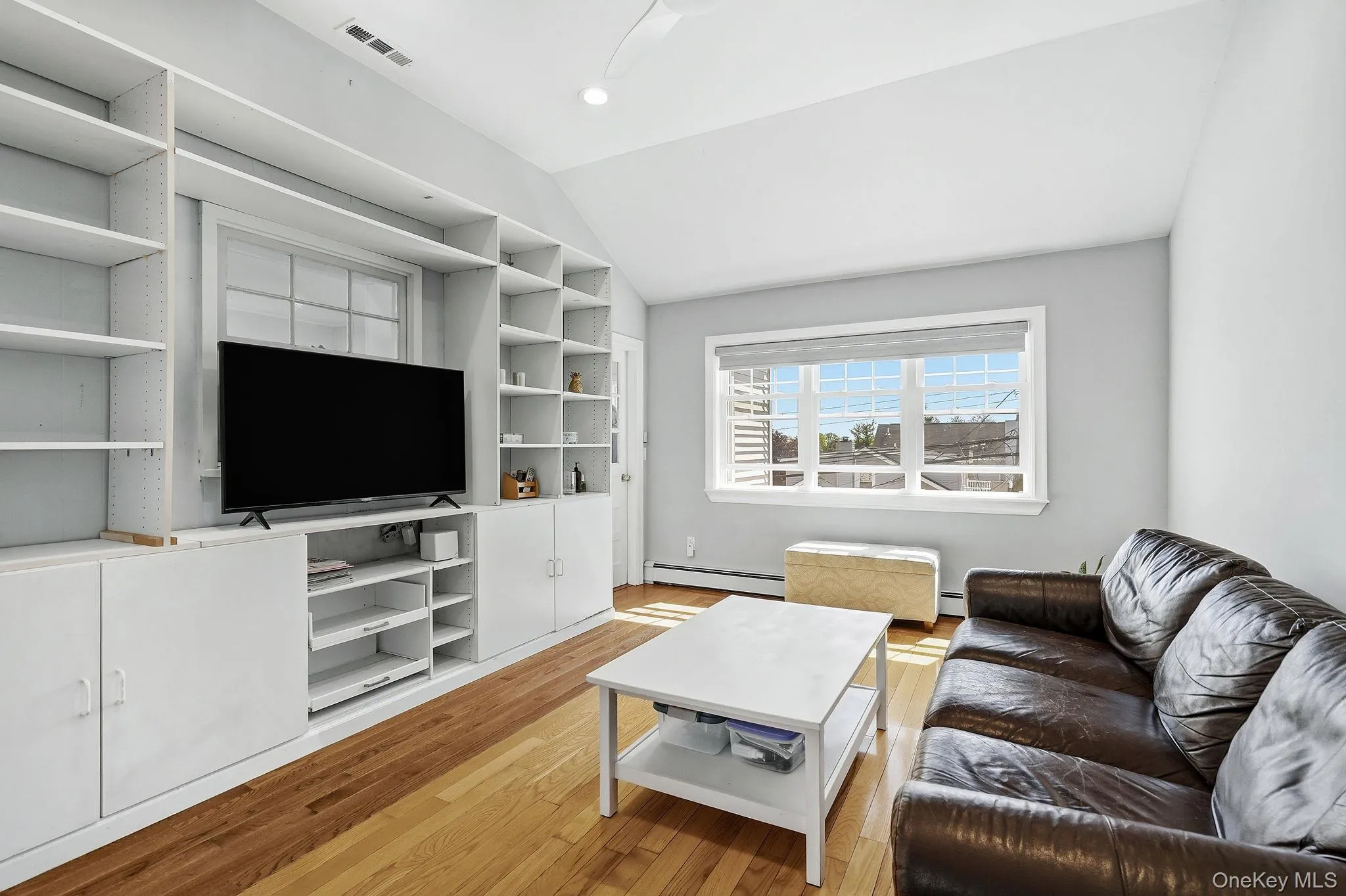 Family room with high ceilings, built-in bookcases and large window Family room with high ceilings, built-in bookcases and large window