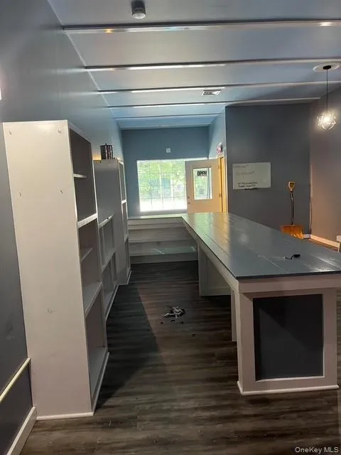 Unfurnished office featuring dark wood finished floors Unfurnished office featuring dark wood finished floors