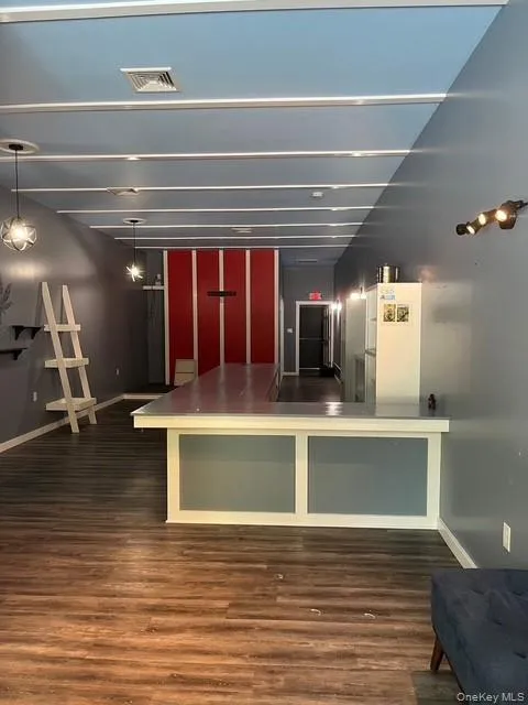 Kitchen with dark wood-type flooring, a peninsula, open floor plan, and dark countertops Kitchen with dark wood-type flooring, a peninsula, open floor plan, and dark countertops
