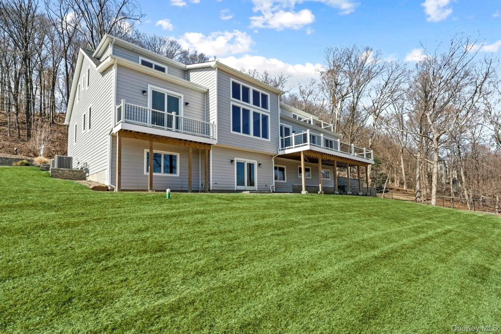 Back of property featuring a yard and a wooden deck Back of property featuring a yard and a wooden deck