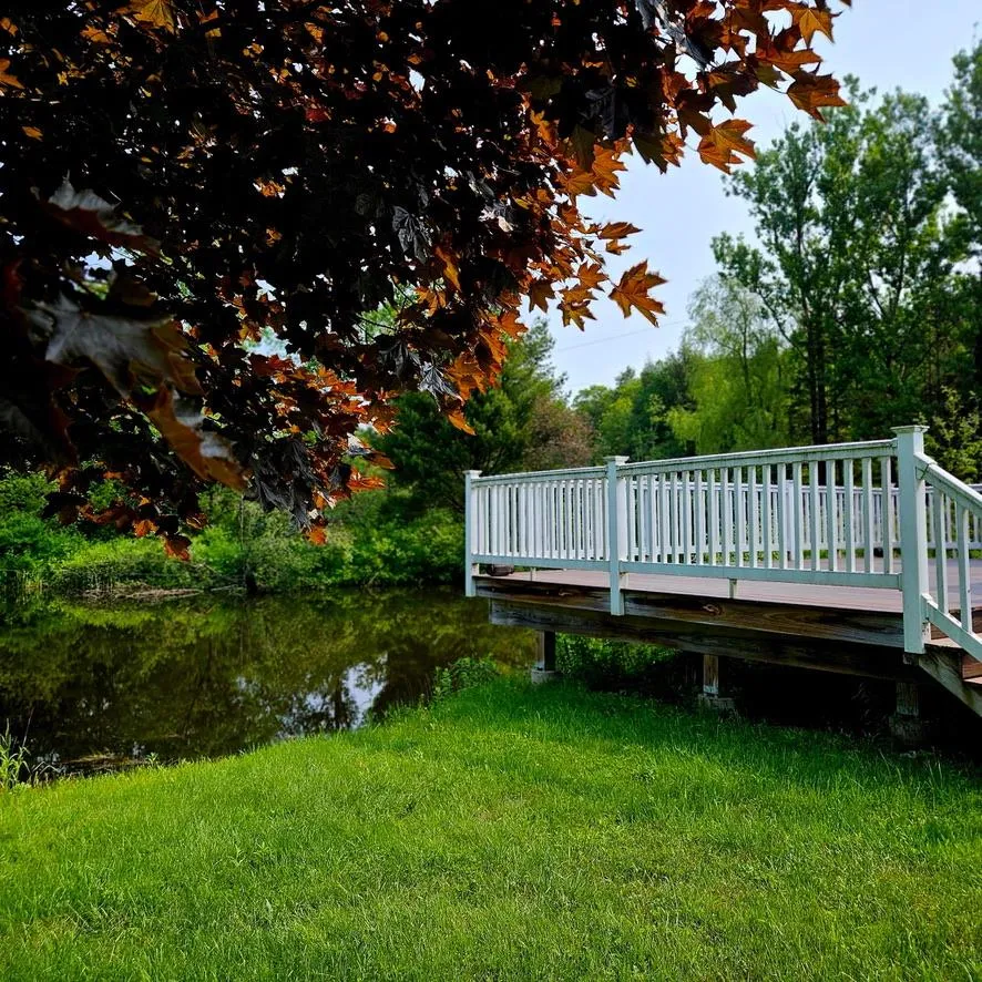 View of green lawn with a wooden deck View of green lawn with a wooden deck