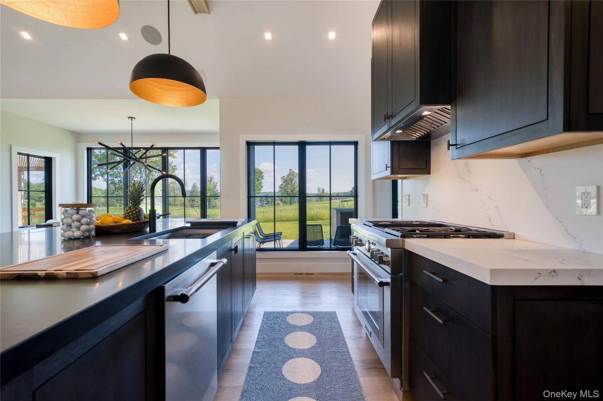 Kitchen with decorative light fixtures, sunlight, sink, and appliances with stainless steel finishes Kitchen with decorative light fixtures, sunlight, sink, and appliances with stainless steel finishes