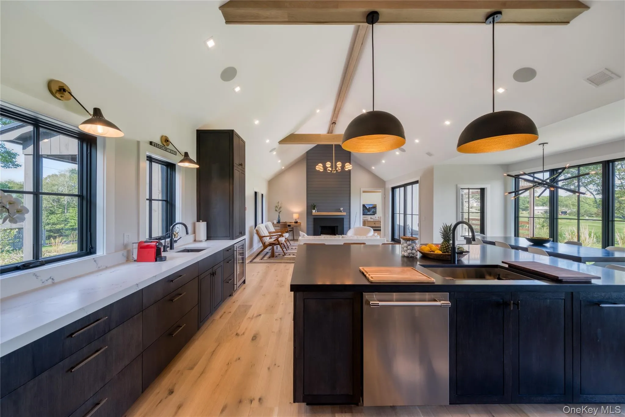 Kitchen with pendant lighting, light wood-type flooring, beam ceiling, and sink Kitchen with pendant lighting, light wood-type flooring, beam ceiling, and sink