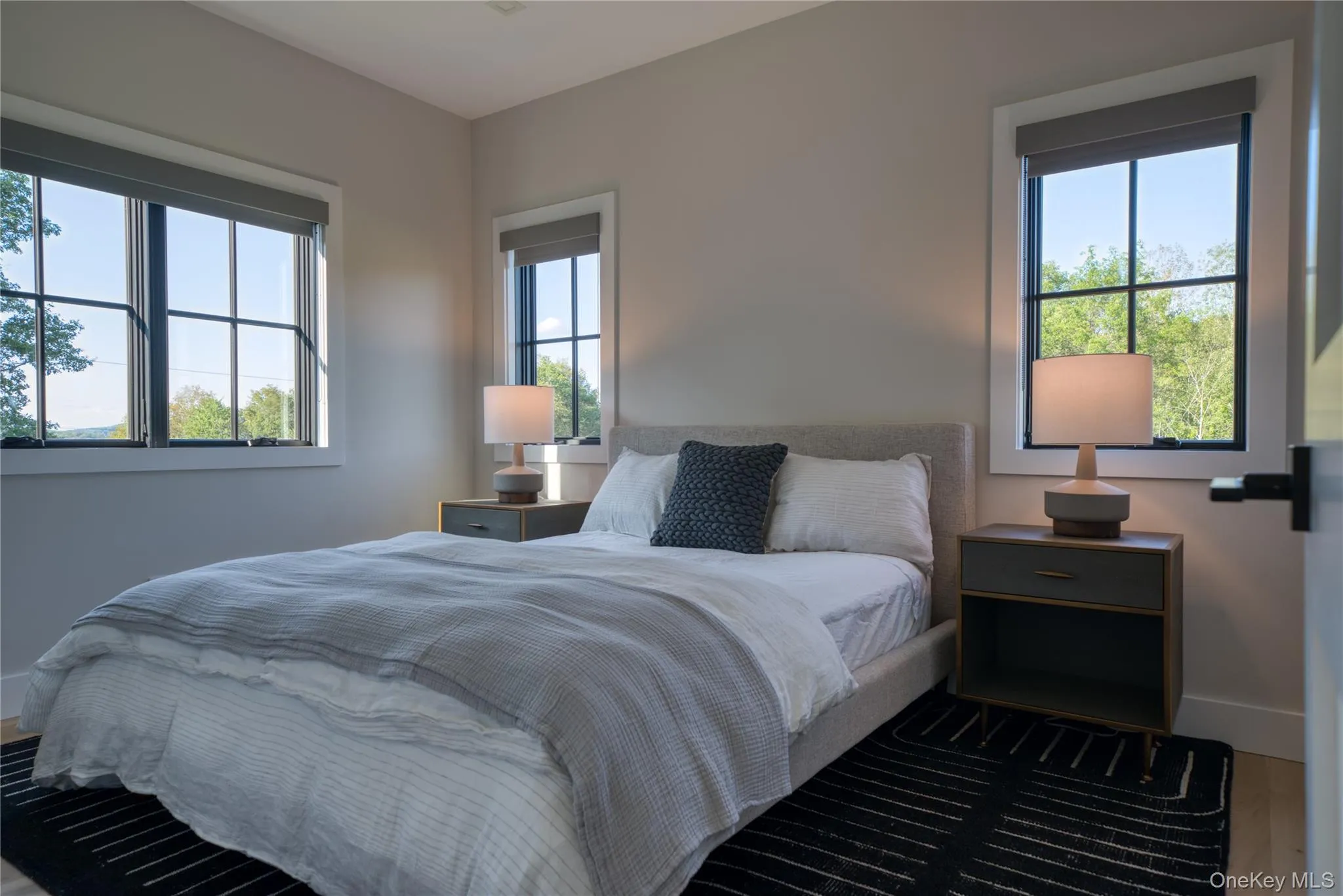 Bedroom with multiple windows and dark wood-type flooring Bedroom with multiple windows and dark wood-type flooring