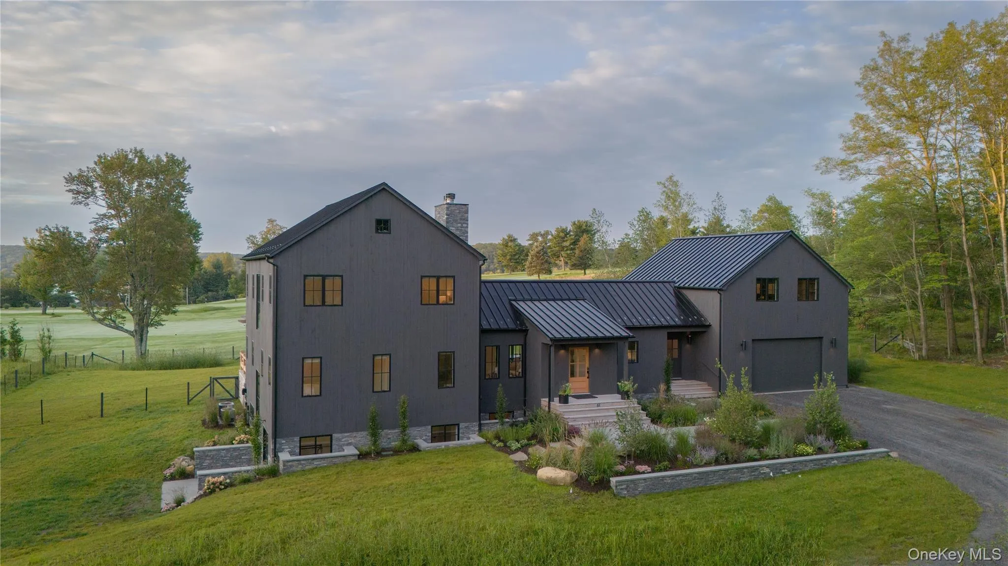 Modern farmhouse showing front yard and garage Modern farmhouse showing front yard and garage