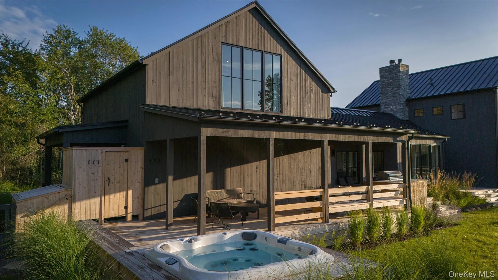 Back of house with an outdoor hot tub Back of house with an outdoor hot tub