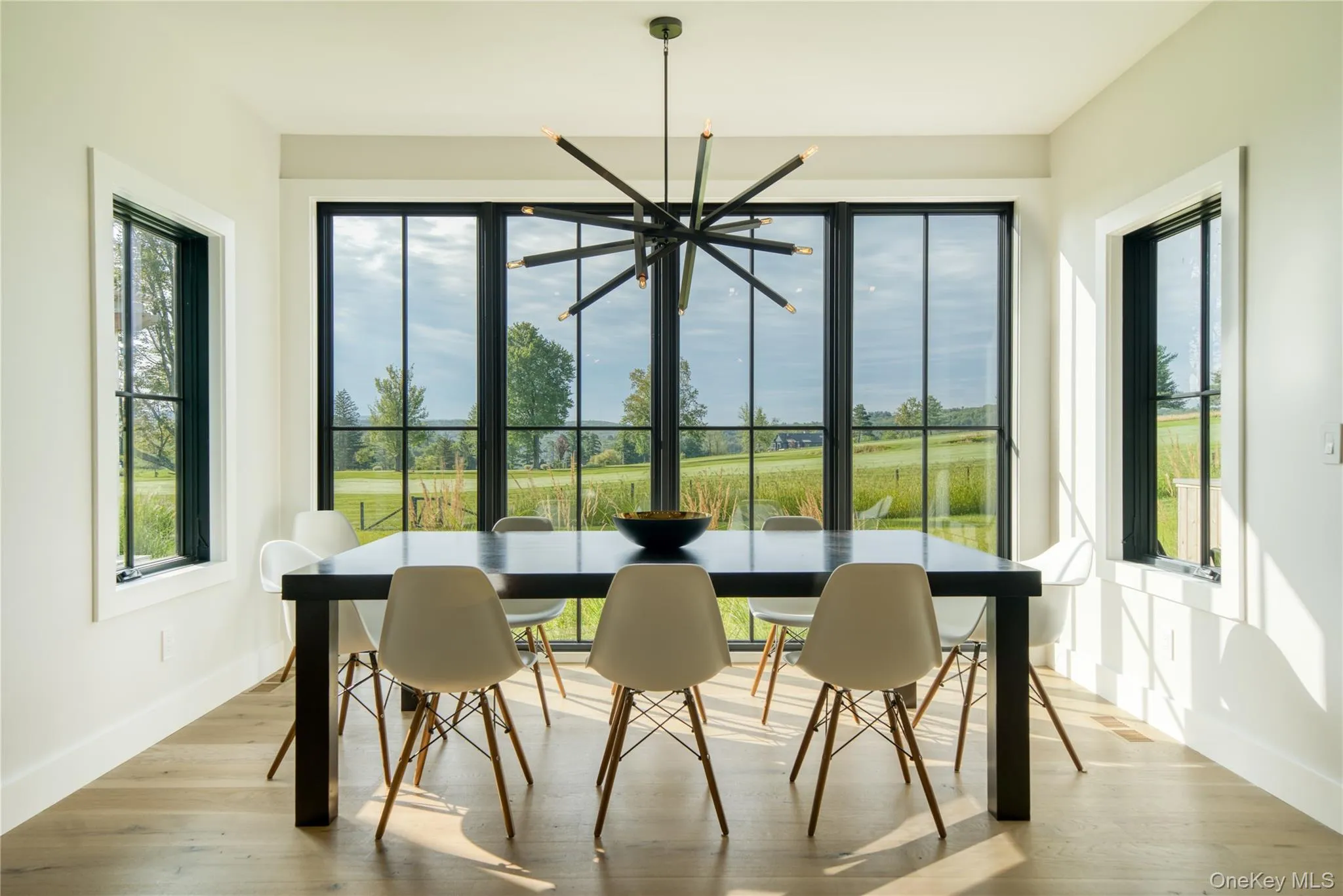 Dining space with an inviting chandelier and wood flooring Dining space with an inviting chandelier and wood flooring