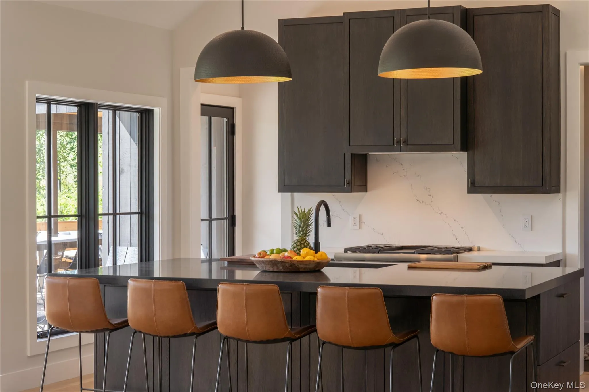 Kitchen featuring tasteful backsplash, an island, and decorative light fixtures Kitchen featuring tasteful backsplash, an island, and decorative light fixtures