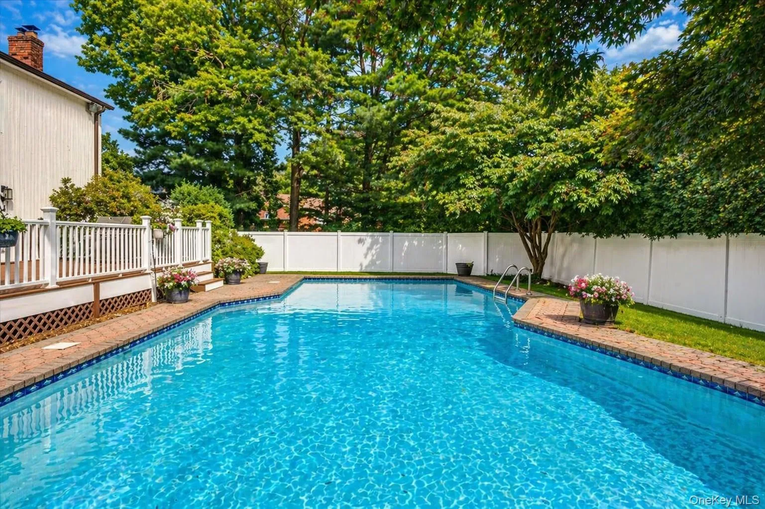 Fully fenced in yard featuring in-ground pool with mature plantings. Fully fenced in yard featuring in-ground pool with mature plantings.