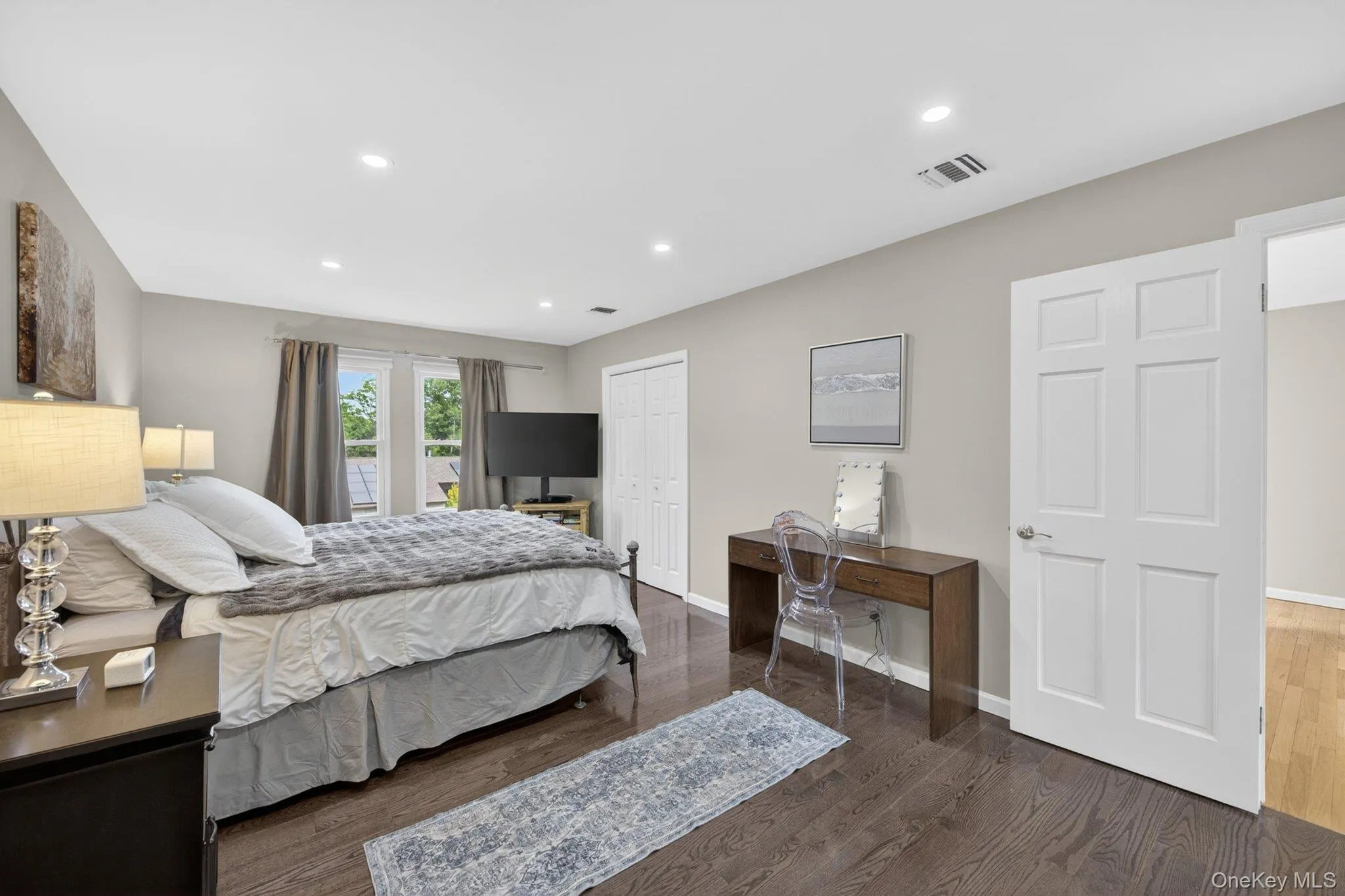 Spacious primary bedroom with multiple closets and recessed lighting. Spacious primary bedroom with multiple closets and recessed lighting.