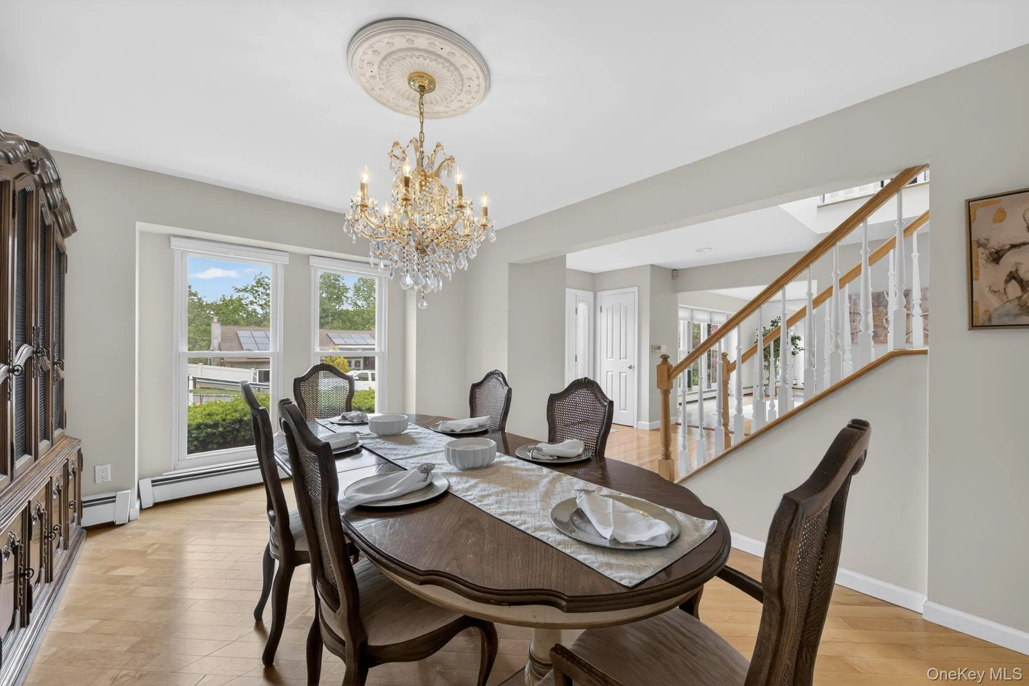 Formal dining room with chandelier and oversized windows. Formal dining room with chandelier and oversized windows.
