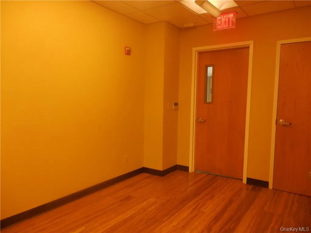 Unfurnished room with a paneled ceiling and hardwood / wood-style flooring Unfurnished room with a paneled ceiling and hardwood / wood-style flooring