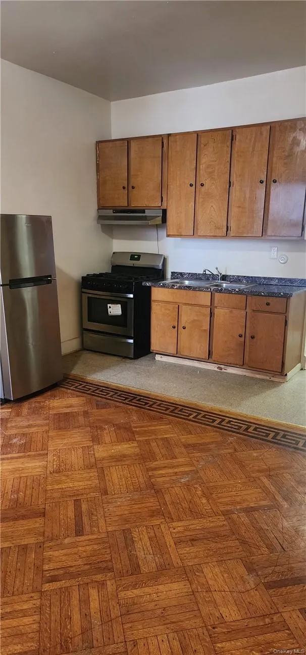 Kitchen featuring light parquet floors and stainless steel appliances Kitchen featuring light parquet floors and stainless steel appliances